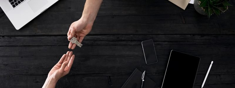 People handing over keys in office